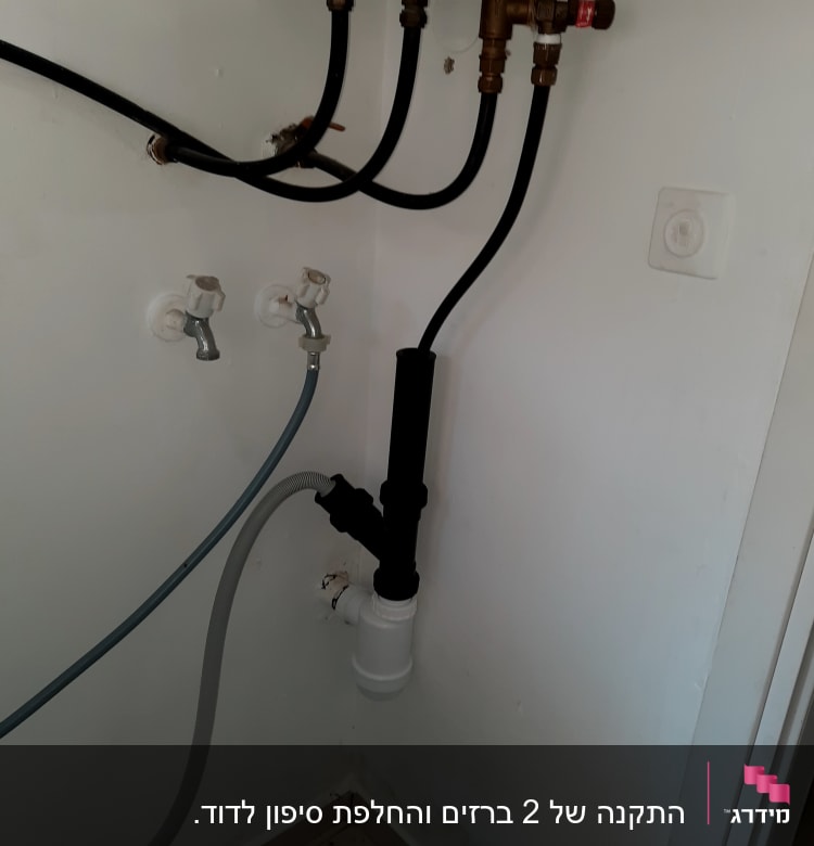 צינורות מים וברזים על קיר לבן